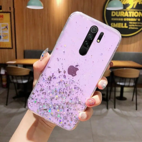 a woman holding a purple phone case with glitter