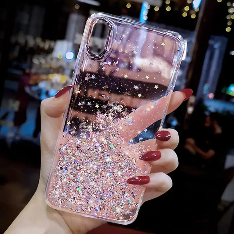 a woman holding up a phone case with glitter
