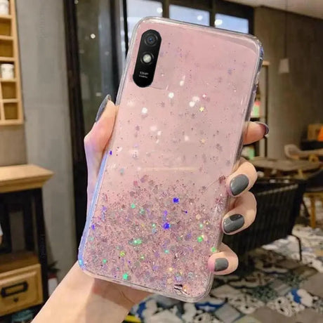 a woman holding a pink glitter phone case