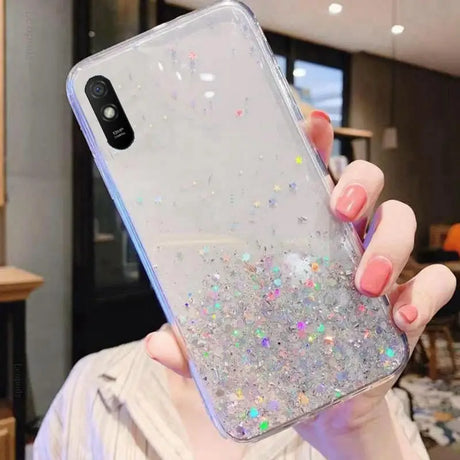 a woman holding a phone case with glitter