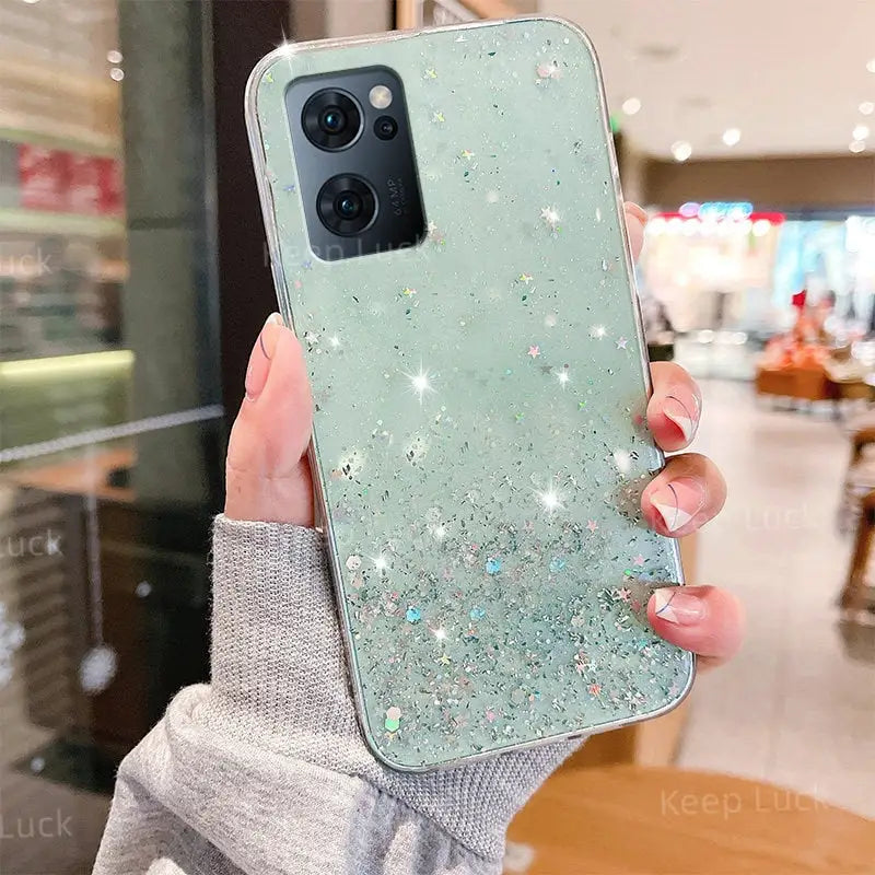 a woman holding up a phone case with glitter