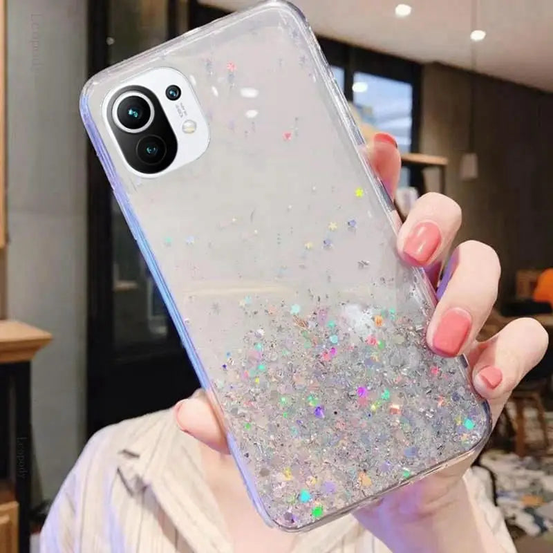 a woman holding a phone case with glitter