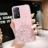 a woman holding a pink phone case with glitter