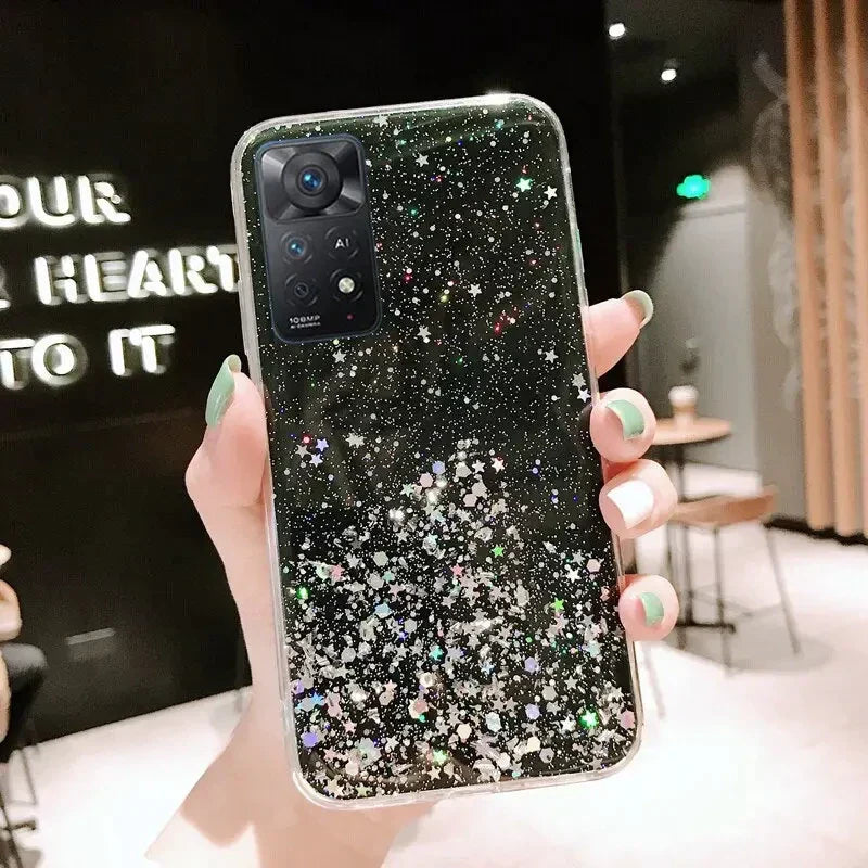 a woman holding up a black glitter phone case