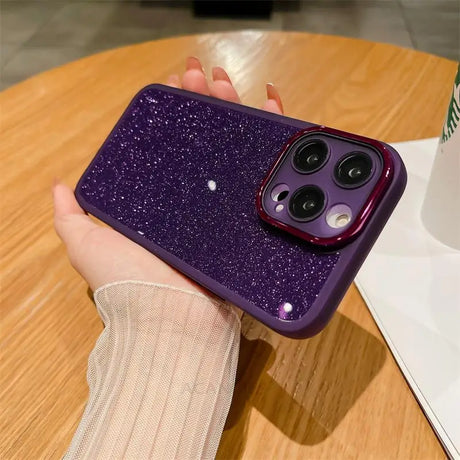 a woman holding a purple glitter phone case