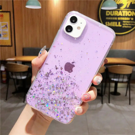 a woman holding a purple phone case with glitter