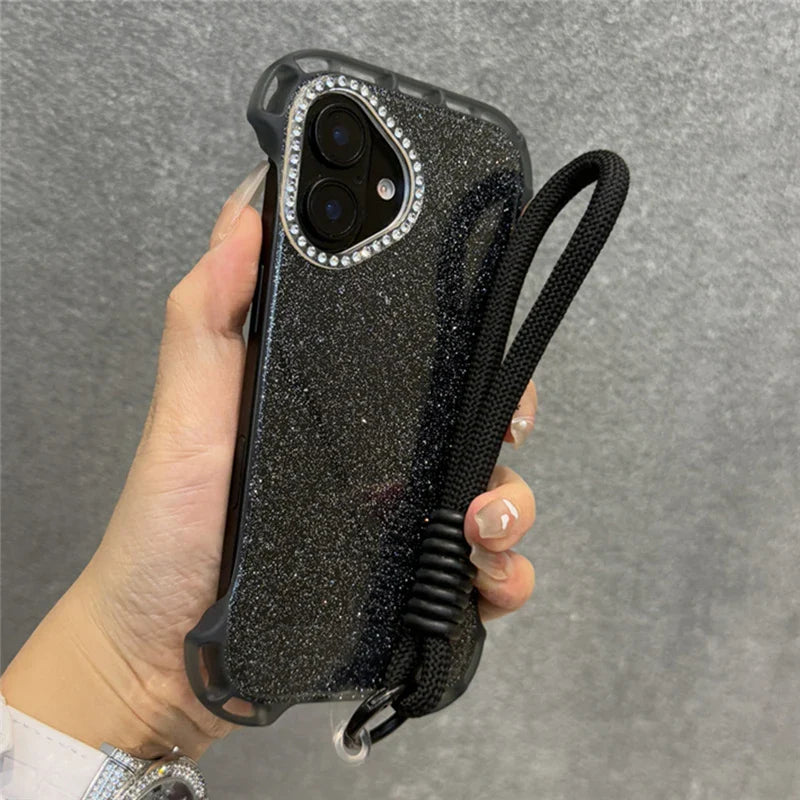 Glittery black phone case with a diamond-studded camera bezel and a black wrist lanyard.