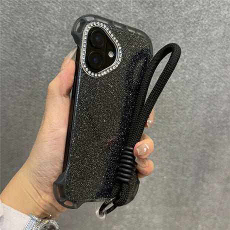 Glittery black phone case with a diamond-studded camera bezel and a black wrist lanyard.