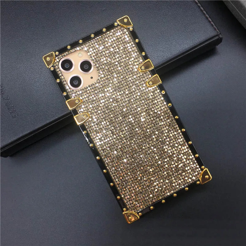 Glittery gold phone case with metallic accents and triple camera cutout.