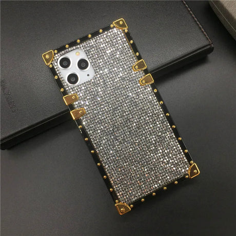 Glittery, gold-trimmed phone case with a triple camera cutout.