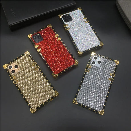 Glittery, jewel-encrusted smartphone cases in various colors with metallic edges.