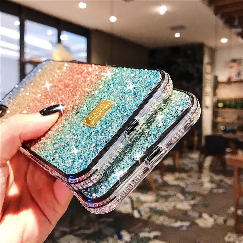 Glittery, multicolored phone case with a gradient effect and rhinestone-studded edges.