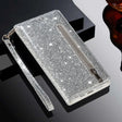 Glittery silver wallet-style phone case with a zipper pocket and wrist strap.