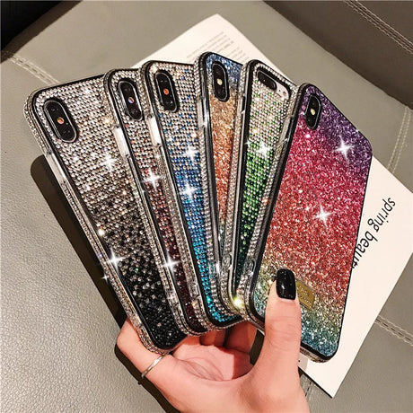 Glittery, sparkly phone cases in various colors fanned out in a hand.