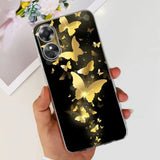 a woman holding a phone case with gold butterflies