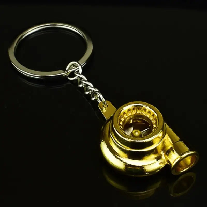 a gold compass keychain on a black background