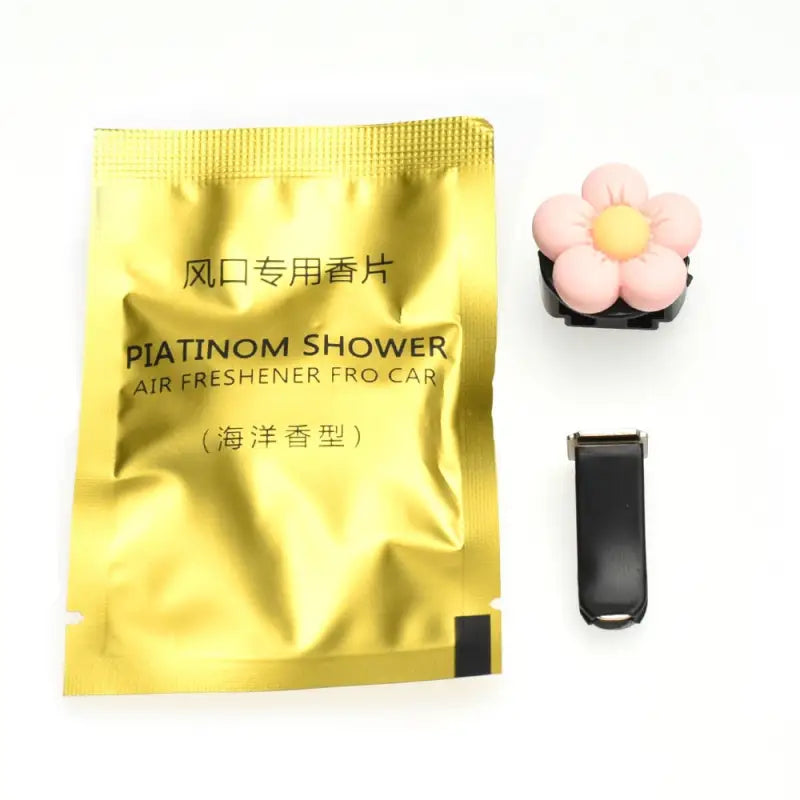 a gold foil packet with a pink flower and a black rubber band