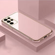 A gold iphone case sitting on top of a pink surface