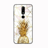 a gold pineapple on marble with geometric shapes