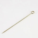 a gold - plated metal pin with a curved end