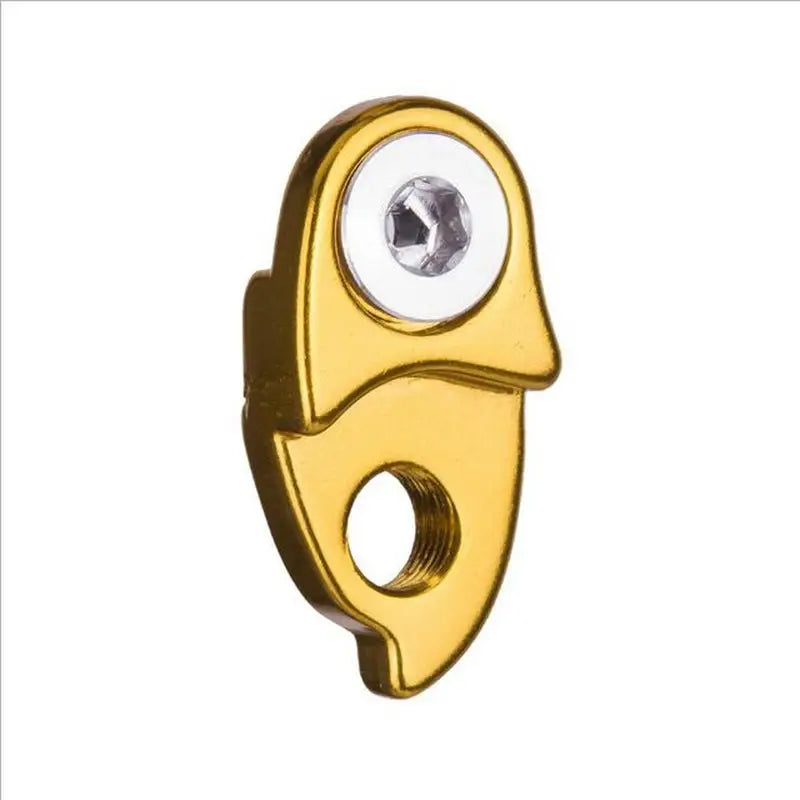 a gold plated metal hook with a white eye