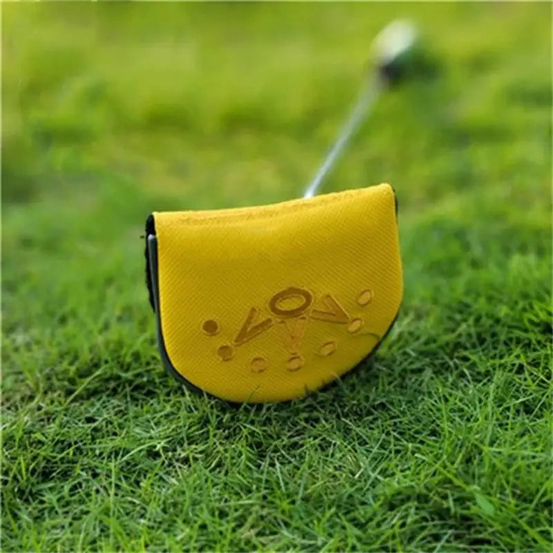 a yellow golf putter on the grass