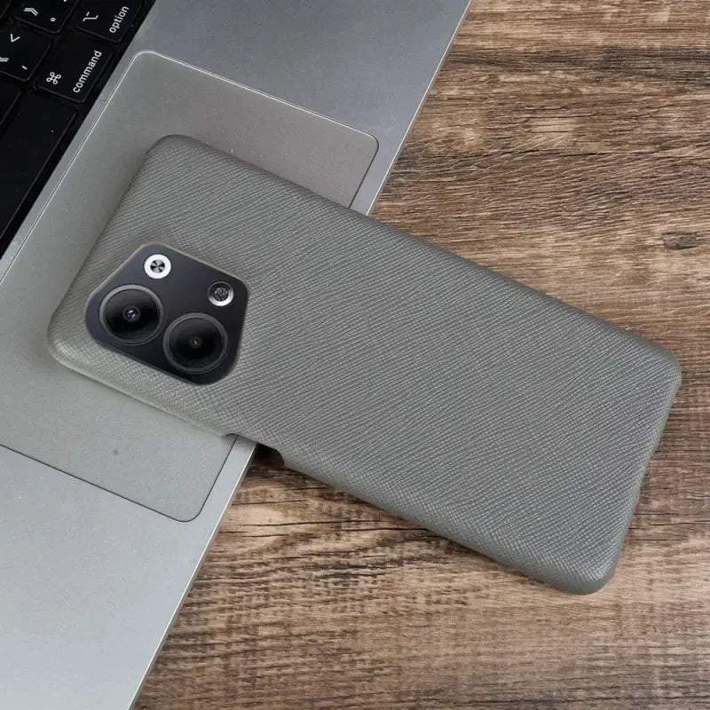 the back of a gray iphone case sitting on top of a laptop