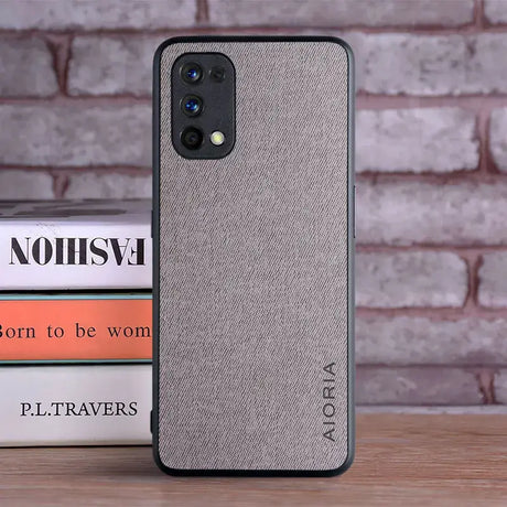 The back of a gray iphone case sitting on a stack of books