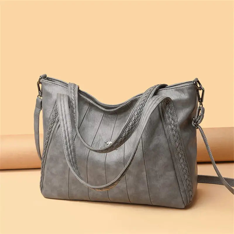 a gray leather bag with braid detailing