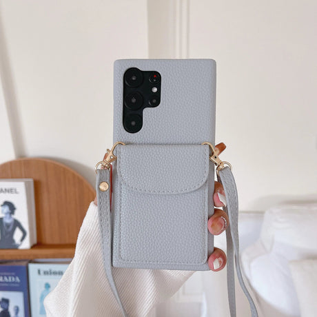 Gray leather smartphone case with a built-in wallet pocket and crossbody strap.