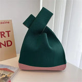 a green bag with a pink handle on top