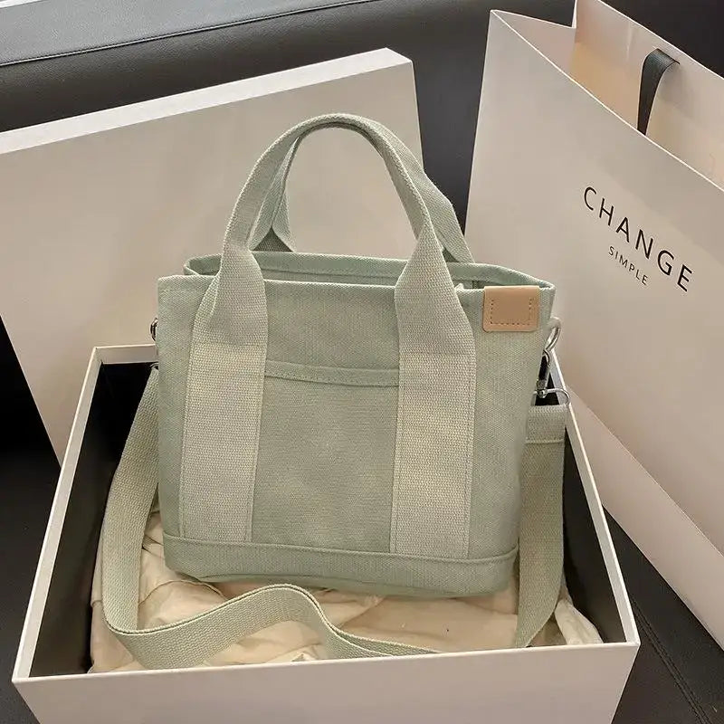 a green bag with a white box and a black box