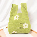 a green bag with white flowers on it