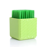 a green plastic brush with a square shape