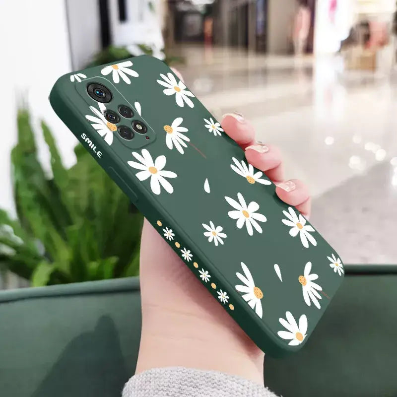 someone holding a green case with white daisies on it