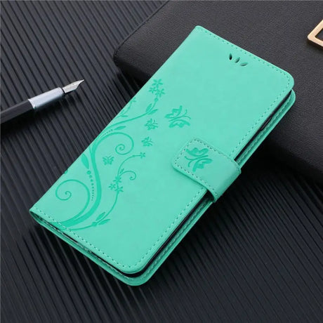 a green leather wallet case with a flower design