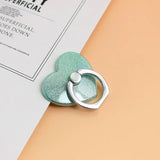 a green heart shaped ring on a white sheet