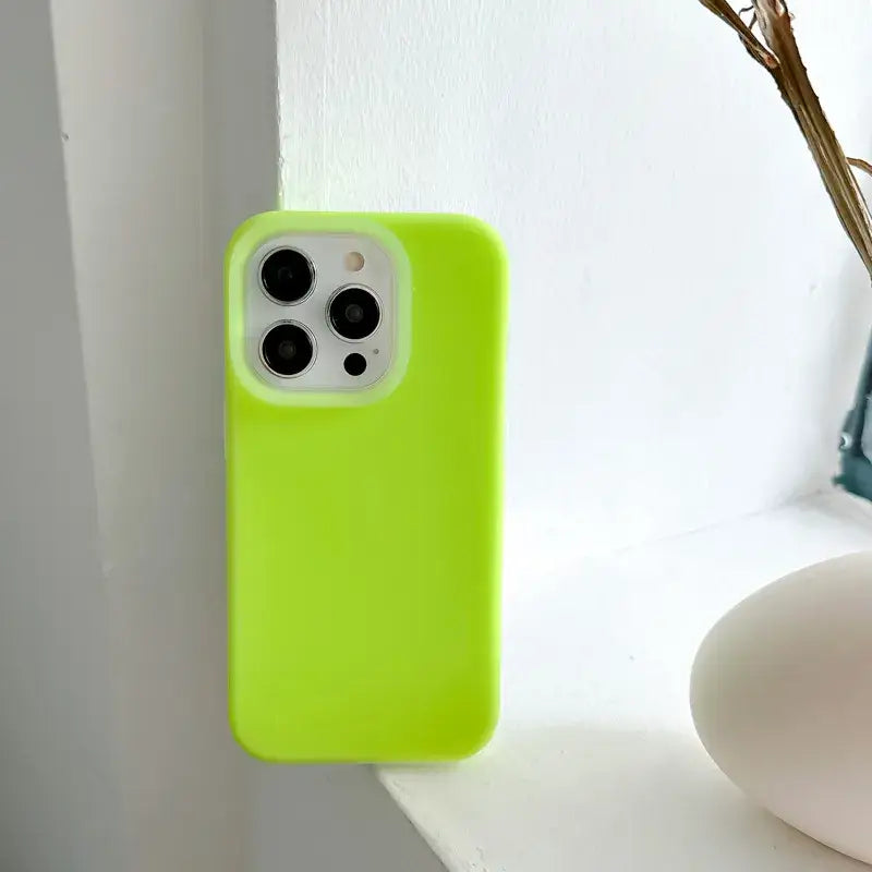 a green iphone case sitting on a white shelf