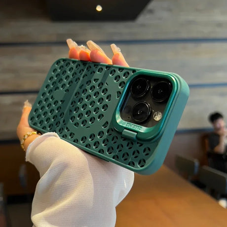 Green lattice-patterned phone case with a camera cutout, held by a hand with painted nails.