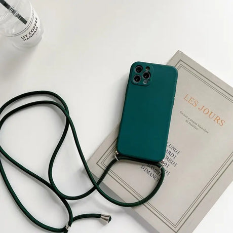 a green phone case sitting on top of a book