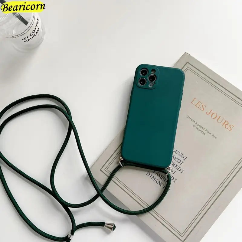a green phone case sitting on top of a book