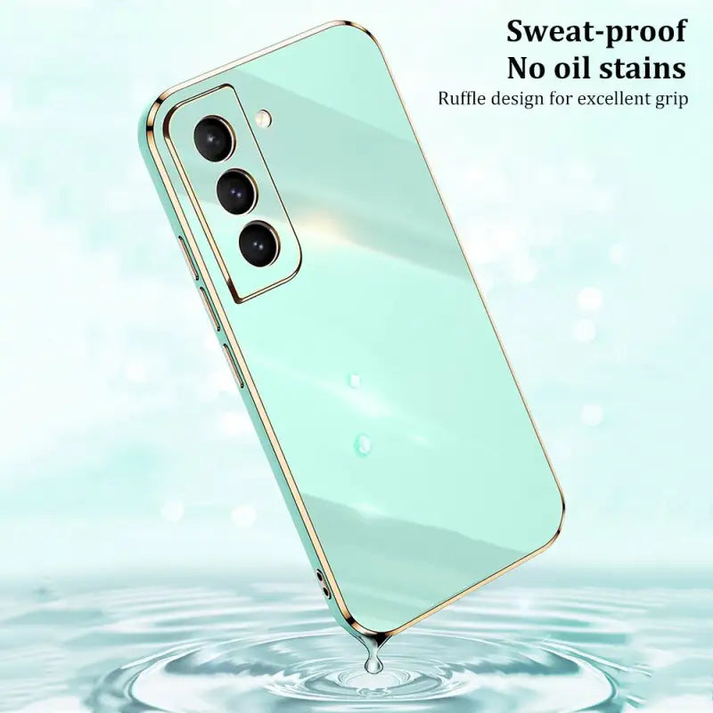 the back of a green phone with water splashing around it