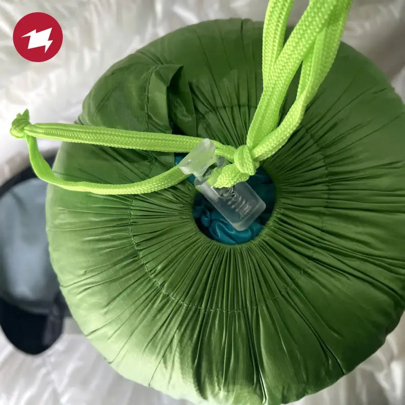 a green pillow with a green ribbon tied around it