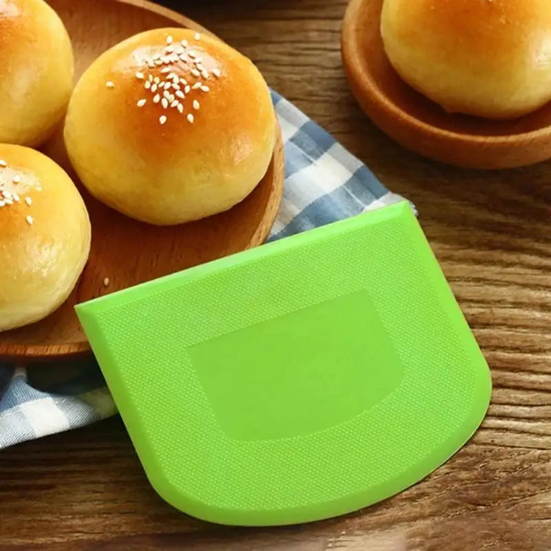 a green plastic cutting board with a bowl of rolls