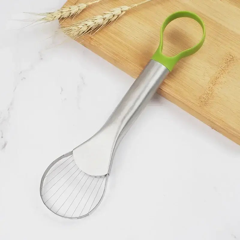 a green spat with a metal handle on a cutting board