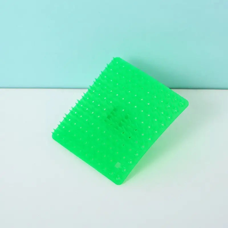 a green plastic comb with a white background