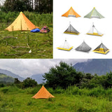 several different tents are set up in a field with mountains in the background