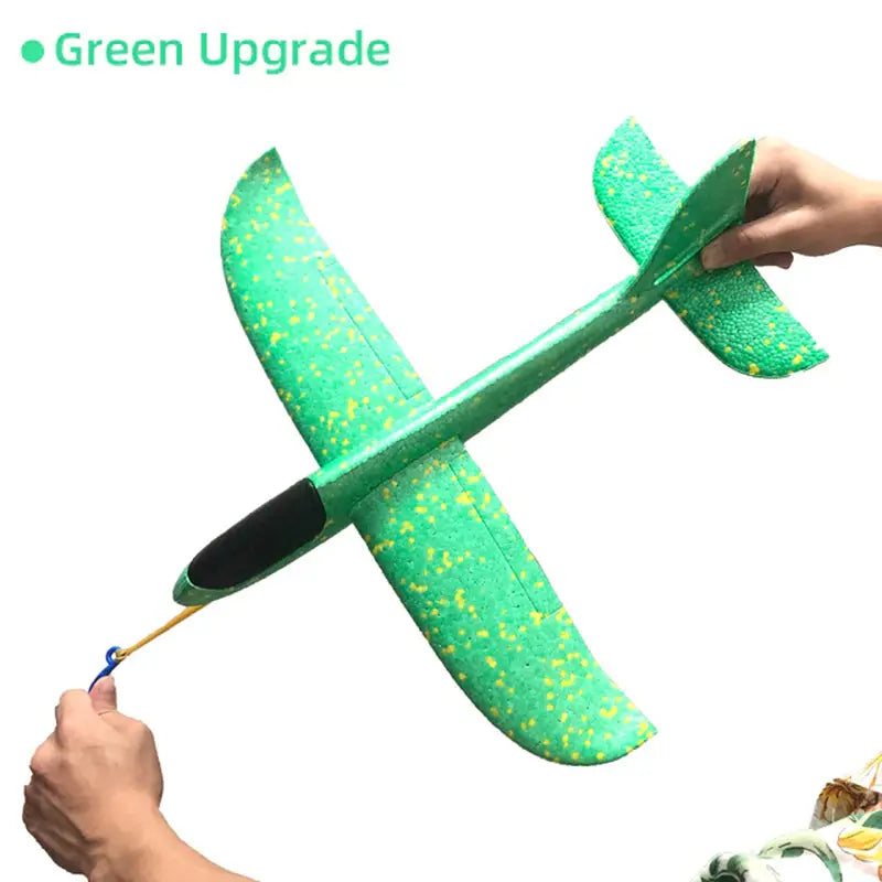a person holding a green airplane with yellow paint