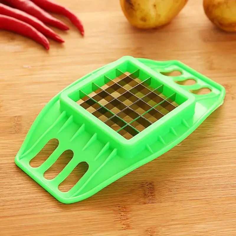 a green vegetable cutter on a wooden cutting board