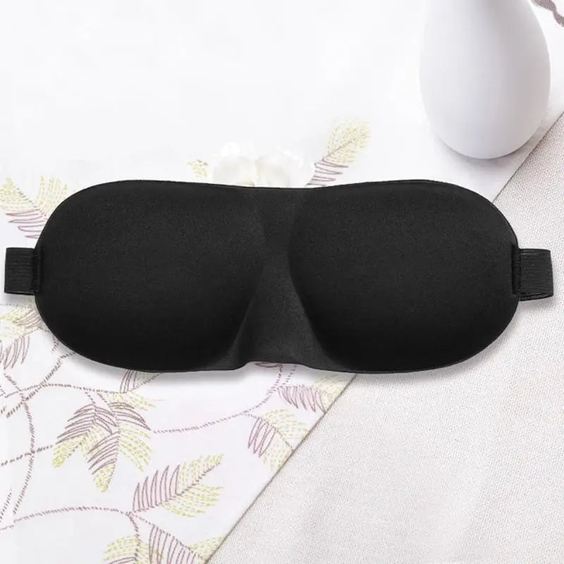 a black eye mask with a white cup on the side